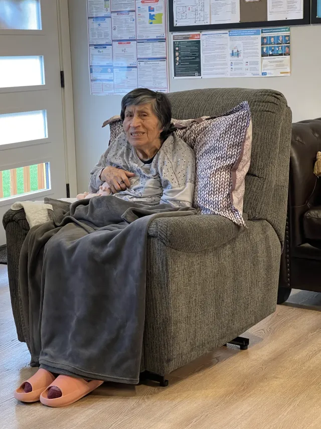 A resident resting in a recliner in the living room.