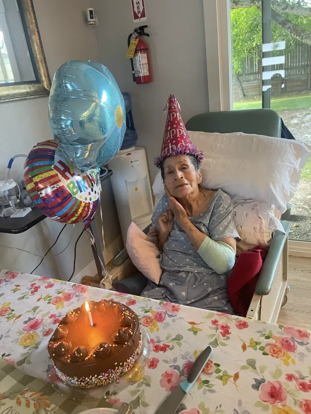 A resident celebrates a birthday with a cake and balloons.